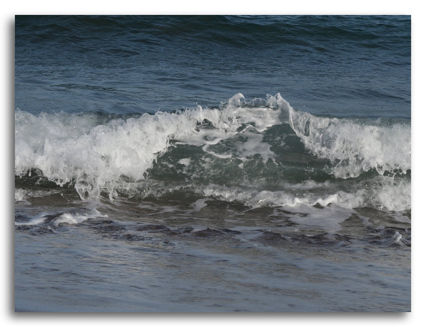 Une vague se brise une vague épuisée