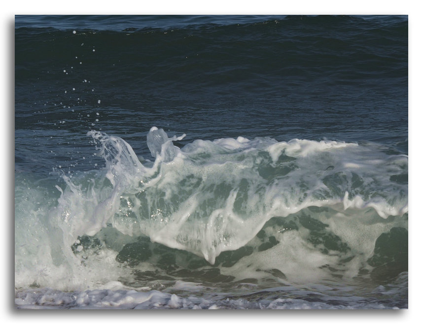 Une vague se brise une vague épuisée