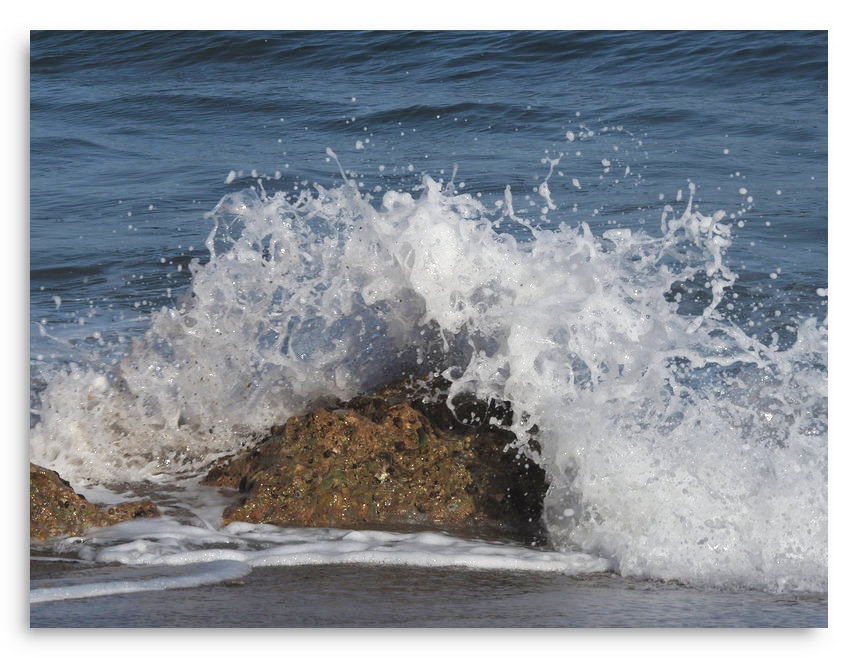 Une vague se brise une vague épuisée
